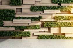 Wall made of wooden blocks and green plants 