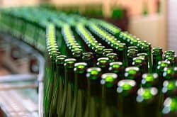Empty green bottles on conveyor belt in factory