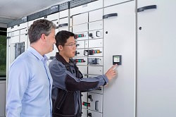 Men checking power meter in a power board
